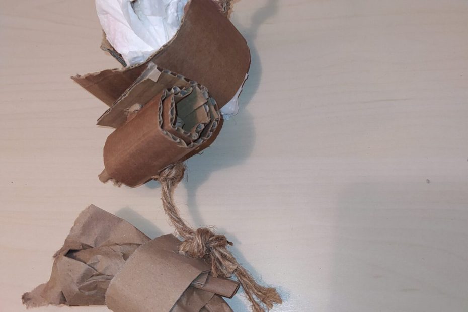 Jouet composé de morceaux de carton, de papier et de ficelle nouée.