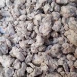 Vue rapprochée de morceaux de litière grise à base de pulpe de papier.
