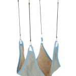Hamac en tissu suspendu par quatre attaches.