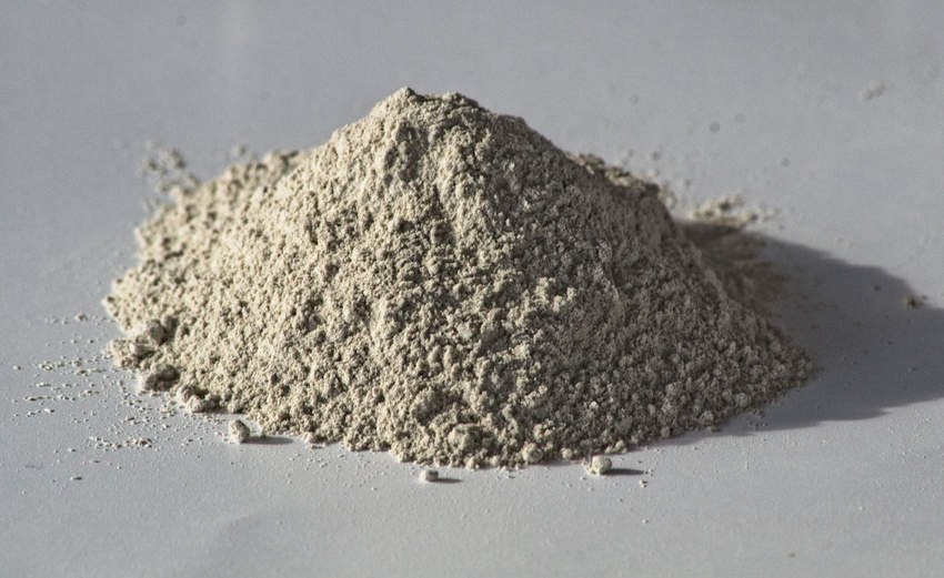 Petit tas de sépiolite broyée de couleur gris clair.